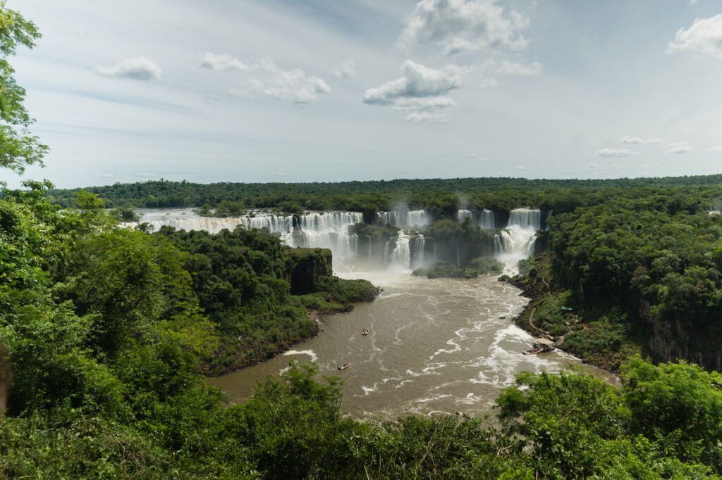 Breathtaking aerial view of the Iguazu Falls surrounded by lush greenery and clear sky.