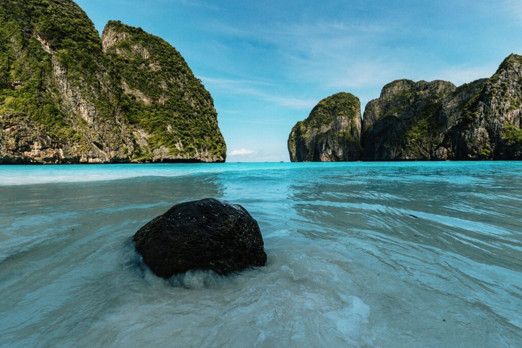 Beautiful beach and limestone cliffs in Krabi, Thailand, under a clear blue sky.
