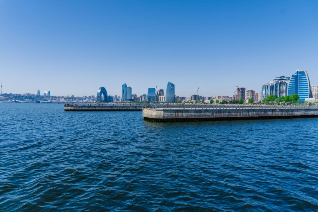 Stunning view of Baku's skyline from the Caspian Sea, featuring modern architecture and clear blue sky.