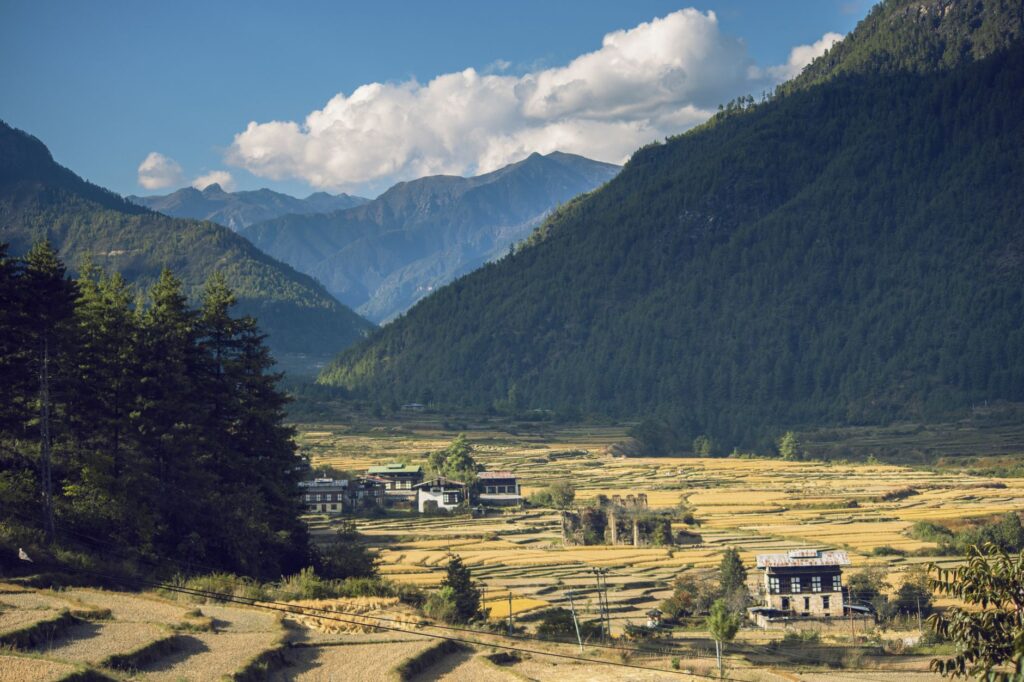 Beautiful mountain valley with rustic village and autumn fields.