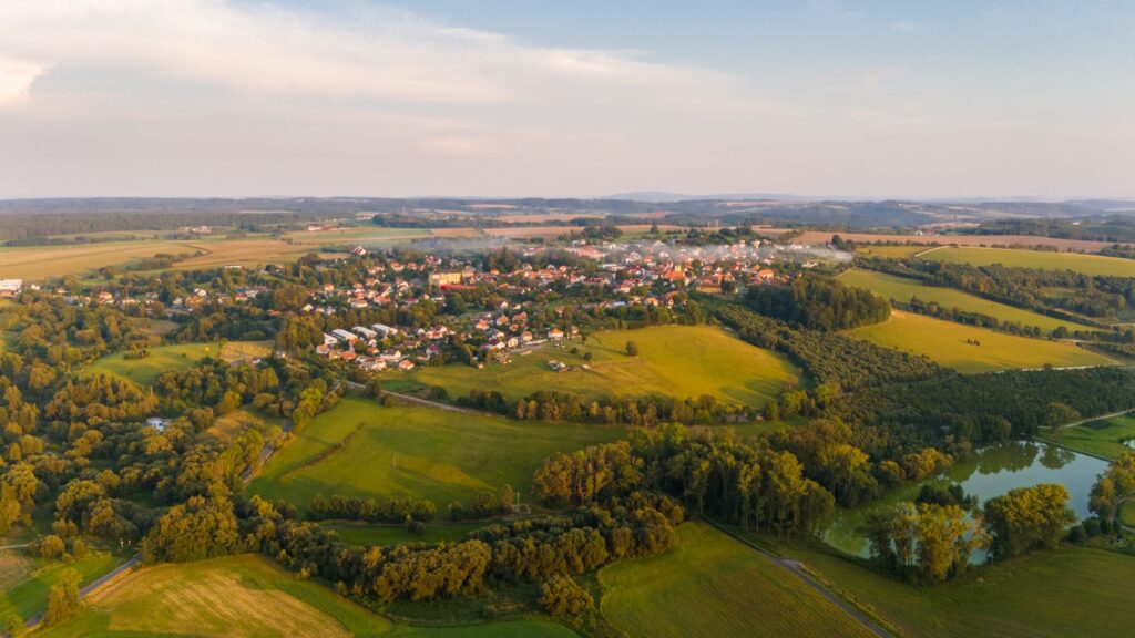 Aerial photo of Zbraslavice, capturing lush green fields and a serene village landscape.