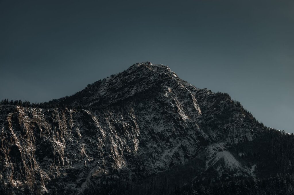 Stunning image of a snow-capped mountain peak under a clear sky, capturing nature's grandeur.