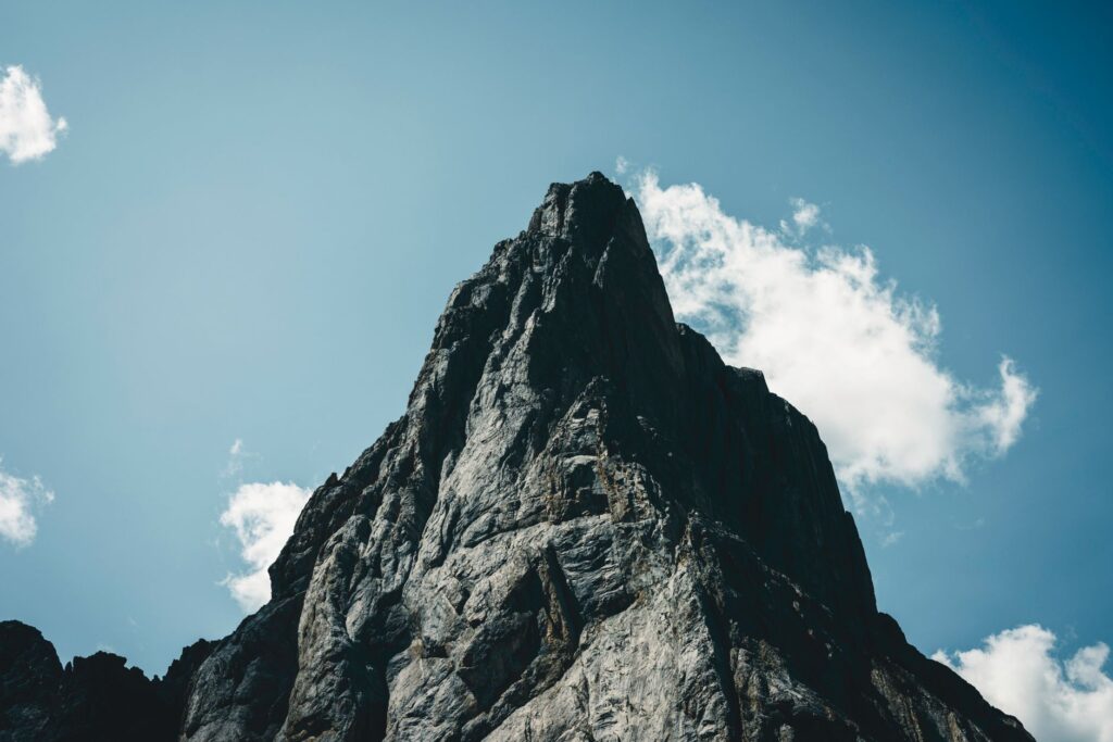 Stunning view of a rocky mountain peak under a clear blue sky in Banff, Alberta.