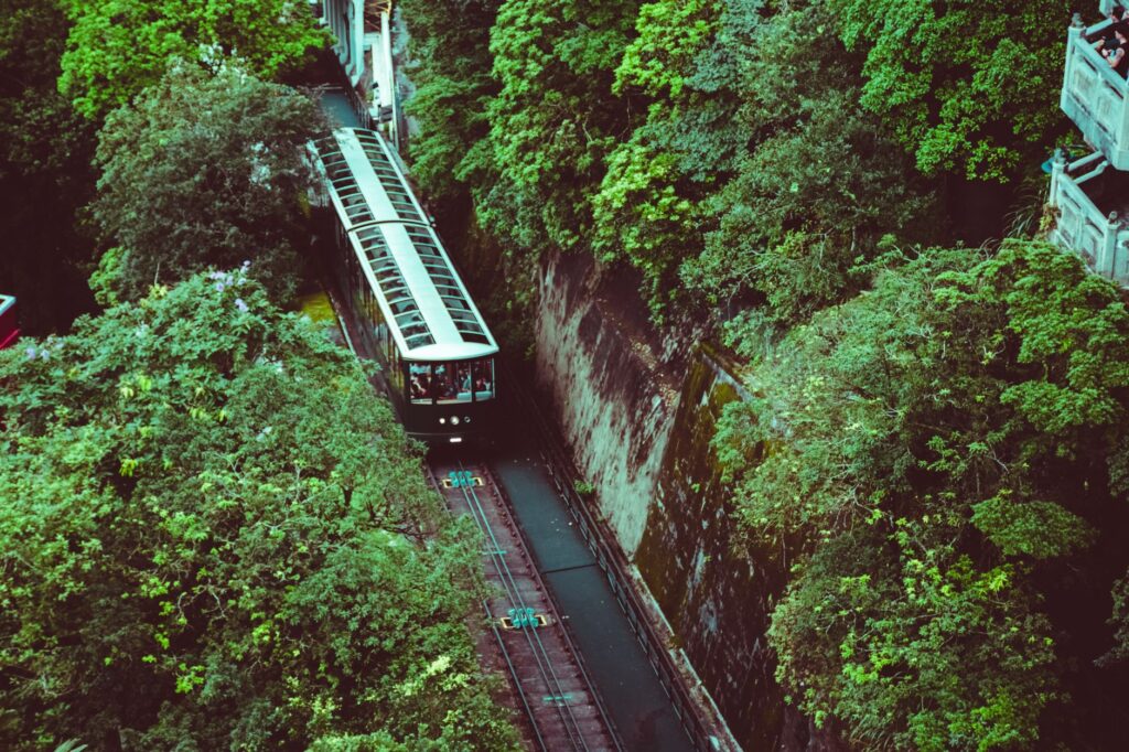 A scenic aerial view of the Hong Kong Peak Tram surrounded by lush greenery, showcasing urban transportation amidst nature.