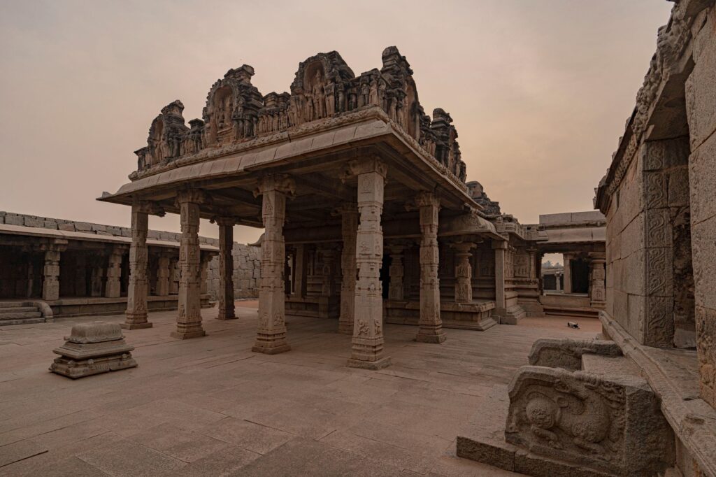 Explore the ancient stone architecture of Hampi, India, showcasing historical columns and intricate carvings.
