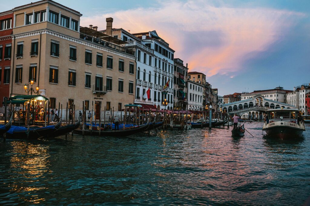 Beautiful view of Venice's Grand Canal with gondolas and historic buildings during twilight.