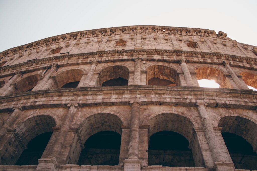 Low angle view of the iconic Colosseum in Rome, Italy showcasing ancient Roman architecture.