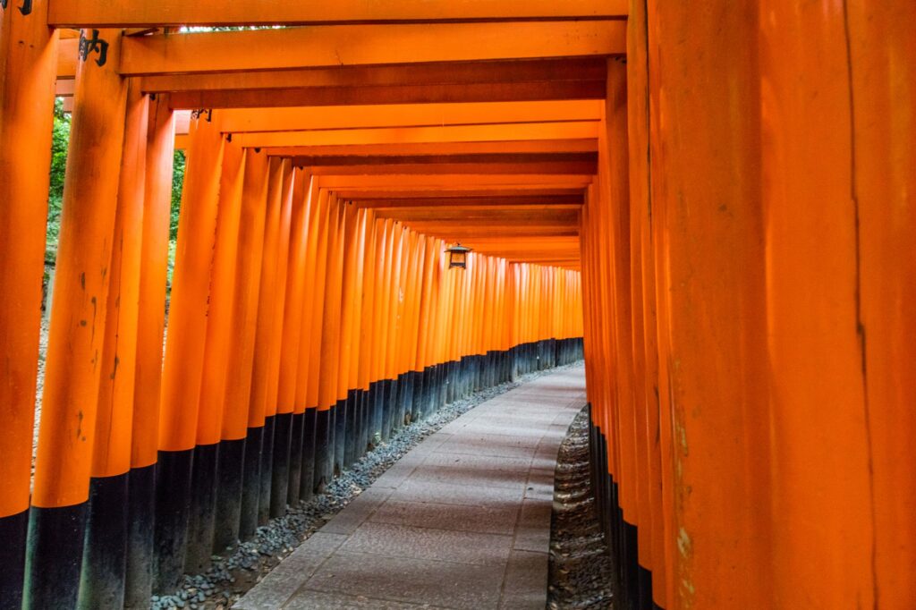 Explore the iconic orange torii gates of Fushimi Inari Shrine in Kyoto, Japan, showcasing traditional Japanese architecture.