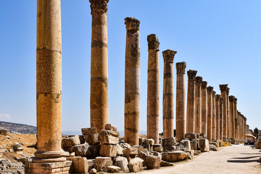 Magnificent columns of the ancient Jerash ruins under a clear blue sky, showcasing historical architecture.