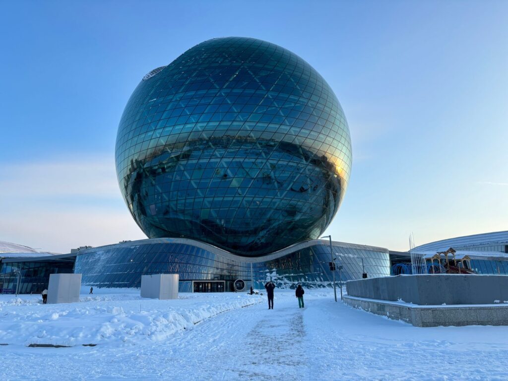 Stunning winter view of Nur Alem, Astana. Reflective sphere against clear blue sky.