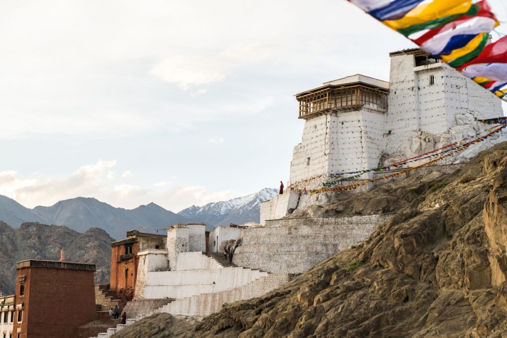 Captivating landscape of Namgyal Tsemo Monastery in Leh with vibrant prayer flags against a serene mountain backdrop.