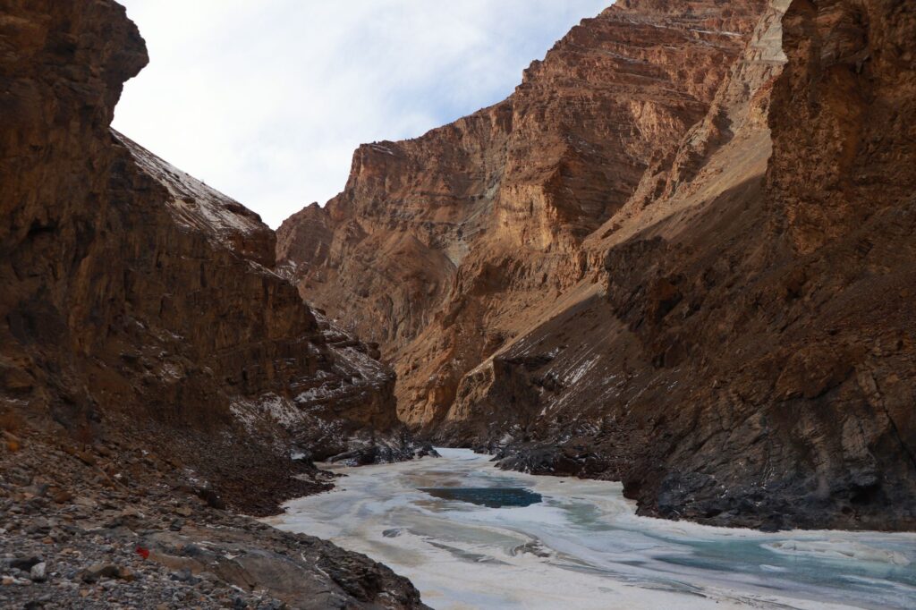 A breathtaking view of the frozen river meandering through the rocky Zanskar Valley Mountains.