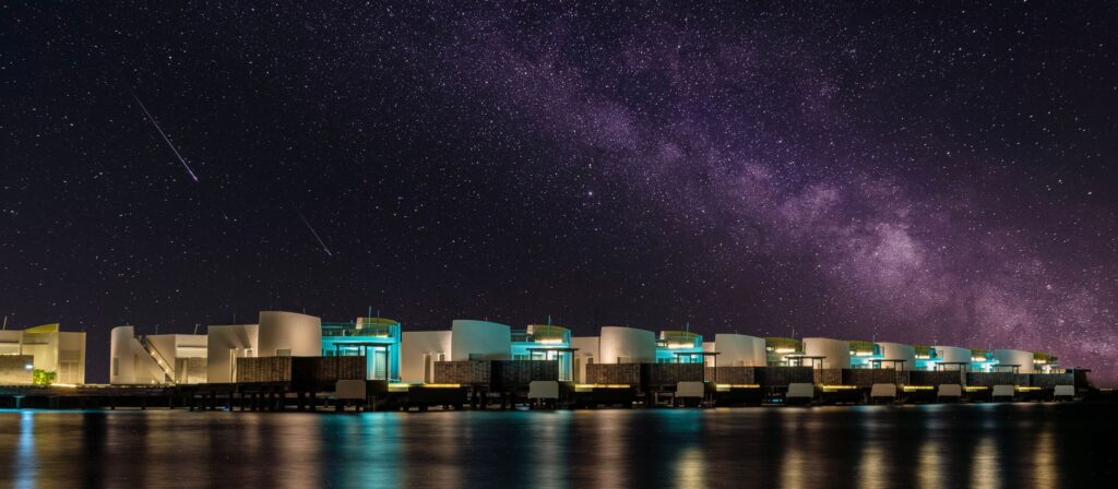 Coastal villas under a mesmerizing starry night sky with the Milky Way.