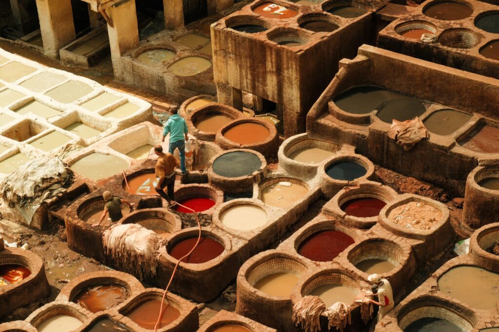Aerial view of vibrant leather dyeing vats at traditional tanneries in Fes, Morocco.