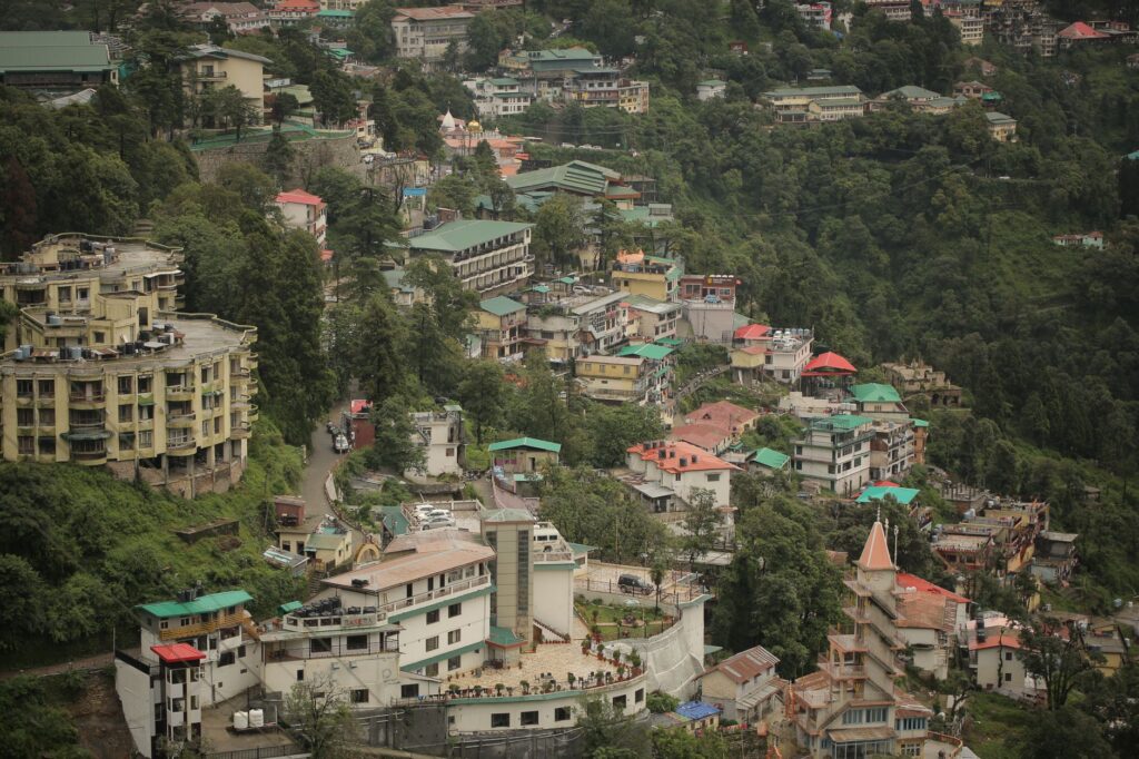 Aerial view of a vibrant city nestled on a hillside surrounded by lush greenery.