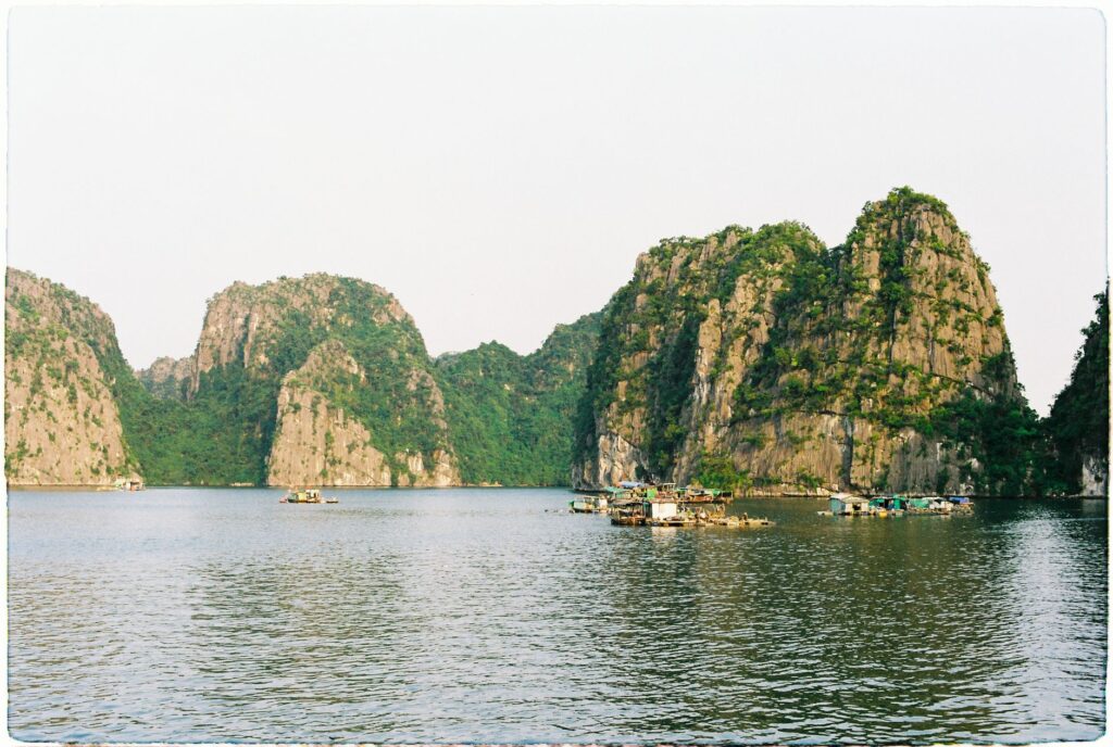 Picturesque view of limestone islands and floating villages in Ha Long Bay, Vietnam at daytime.