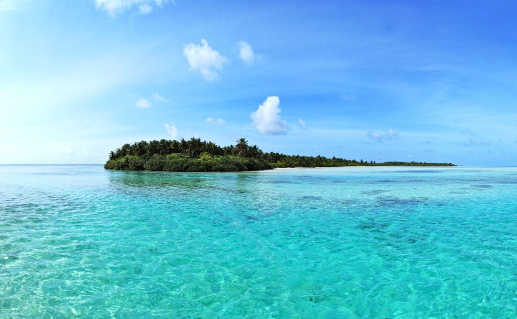 A beautiful tropical island surrounded by clear blue waters and a vivid sky, ideal for travel and vacation.