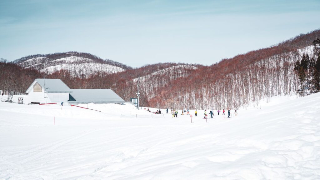 Winter scene at Yuzawa ski resort in Japan with snow-covered slopes and skiers enjoying the day.