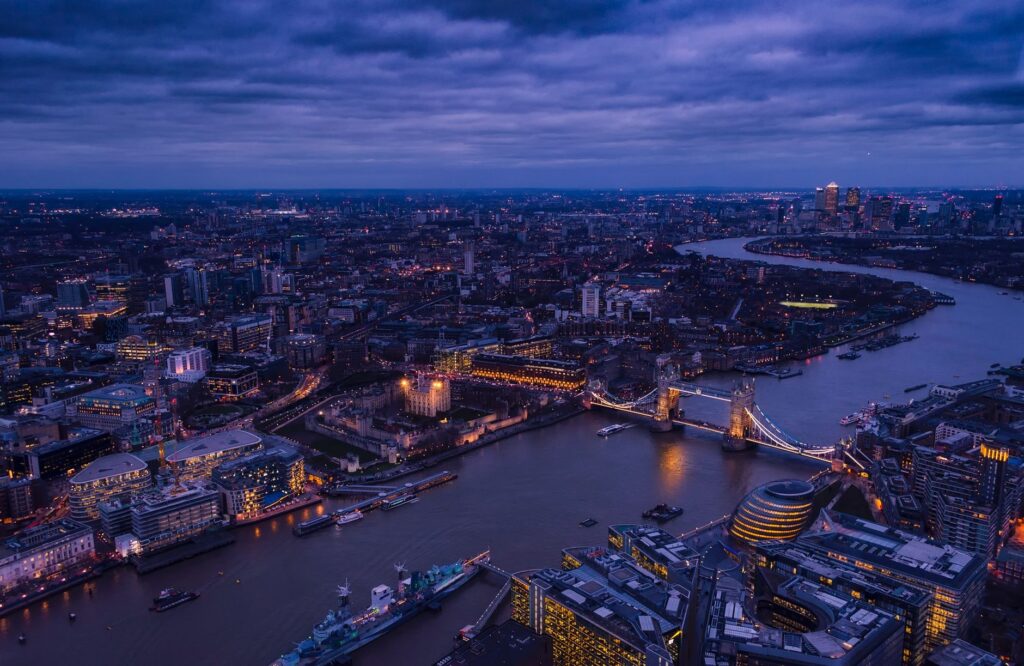 A breathtaking aerial view of London's Tower Bridge and the River Thames illuminated at twilight.