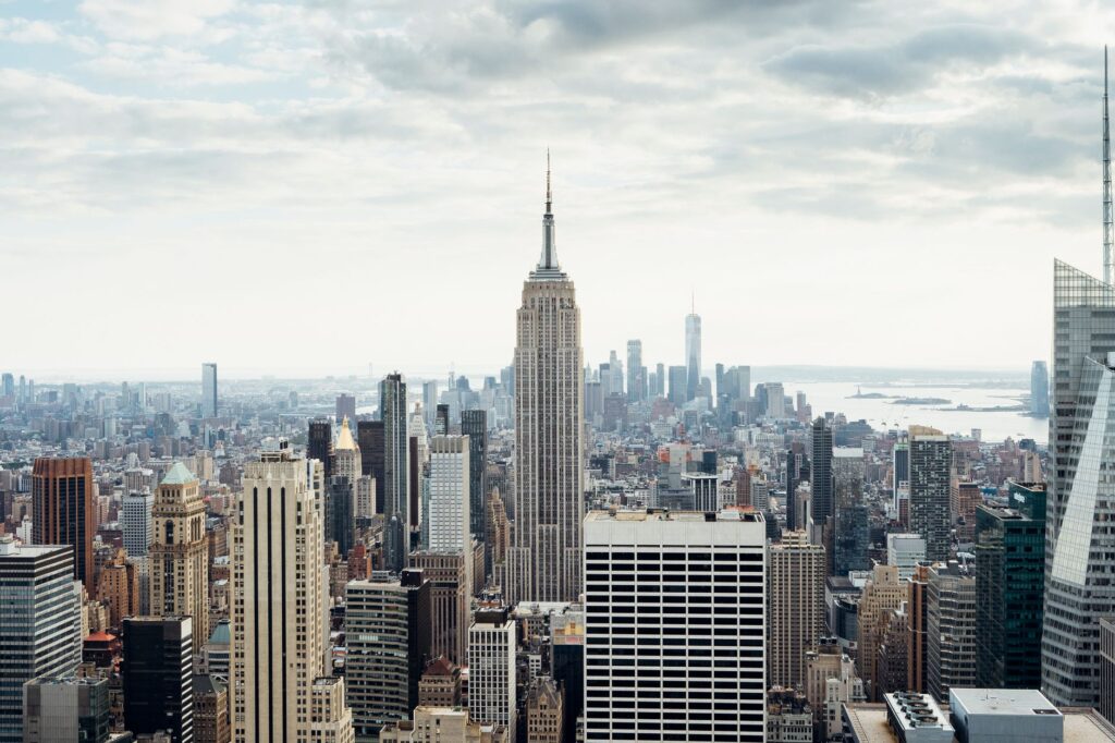 Cityscape of modern megapolis with view on skyscrapers located in New York city in America under cloudy sky in daytime