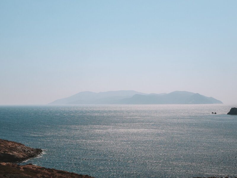 Peaceful view of the Aegean Sea with distant Greek islands under a clear sky.