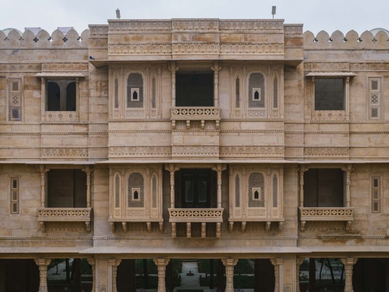 Impressive stone facade of a palace hotel in Jaisalmer, showcasing intricate architectural details.