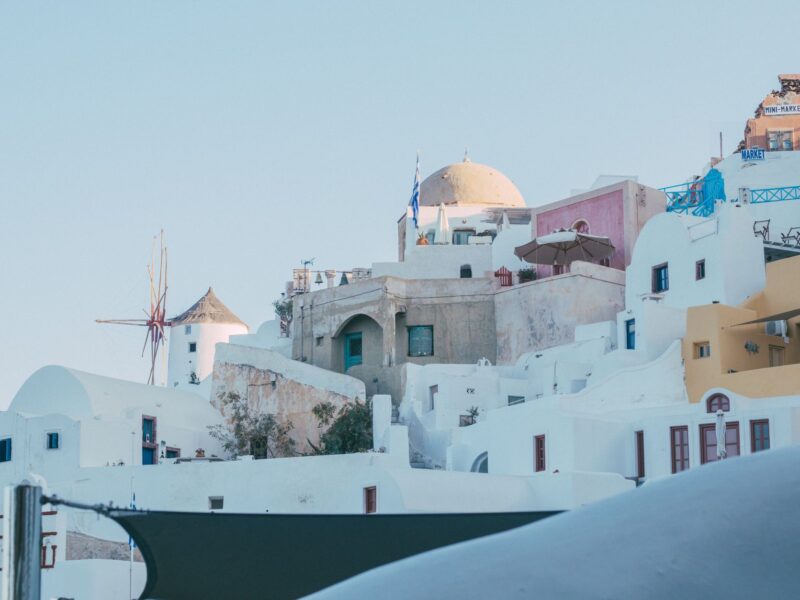 Charming view of Santorini with its unique whitewashed buildings and blue accents. Perfect summer travel inspiration.